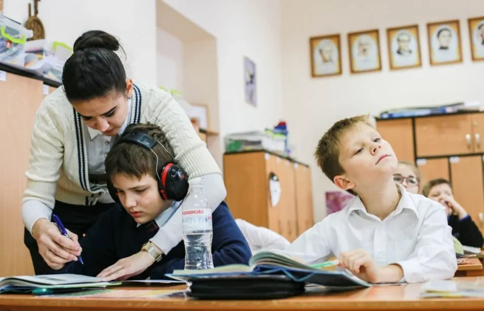 Асистентка допомагає студенту з особливими потребами на занятті в коледжі