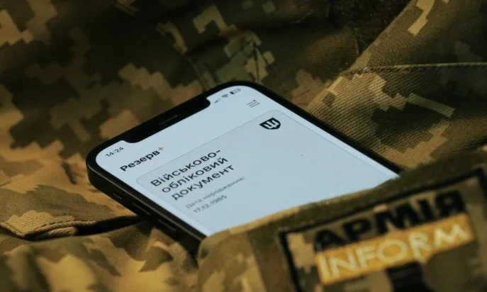 Смартфон з військово-обліковим документом у додатку Резерв+ на камуфляжі