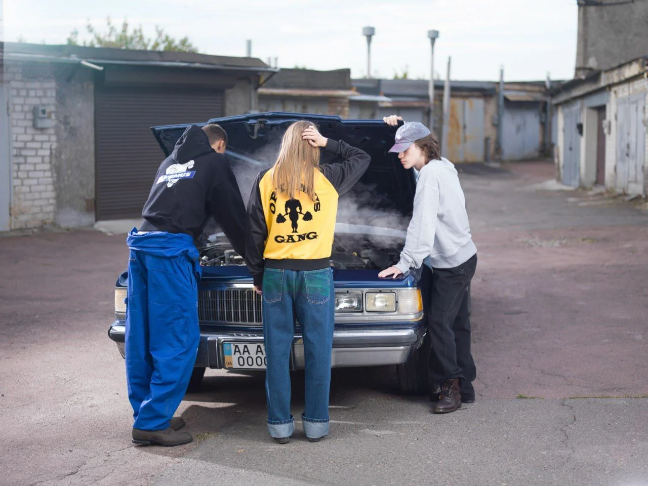Учасники Optimus Gang у фірмових худі ремонтують авто на вулиці
