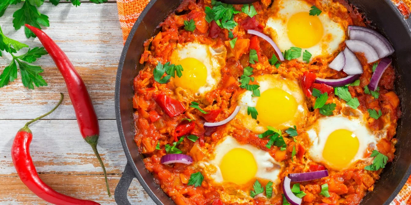 Пікантна шакшука з яйцями та овочами в сковороді