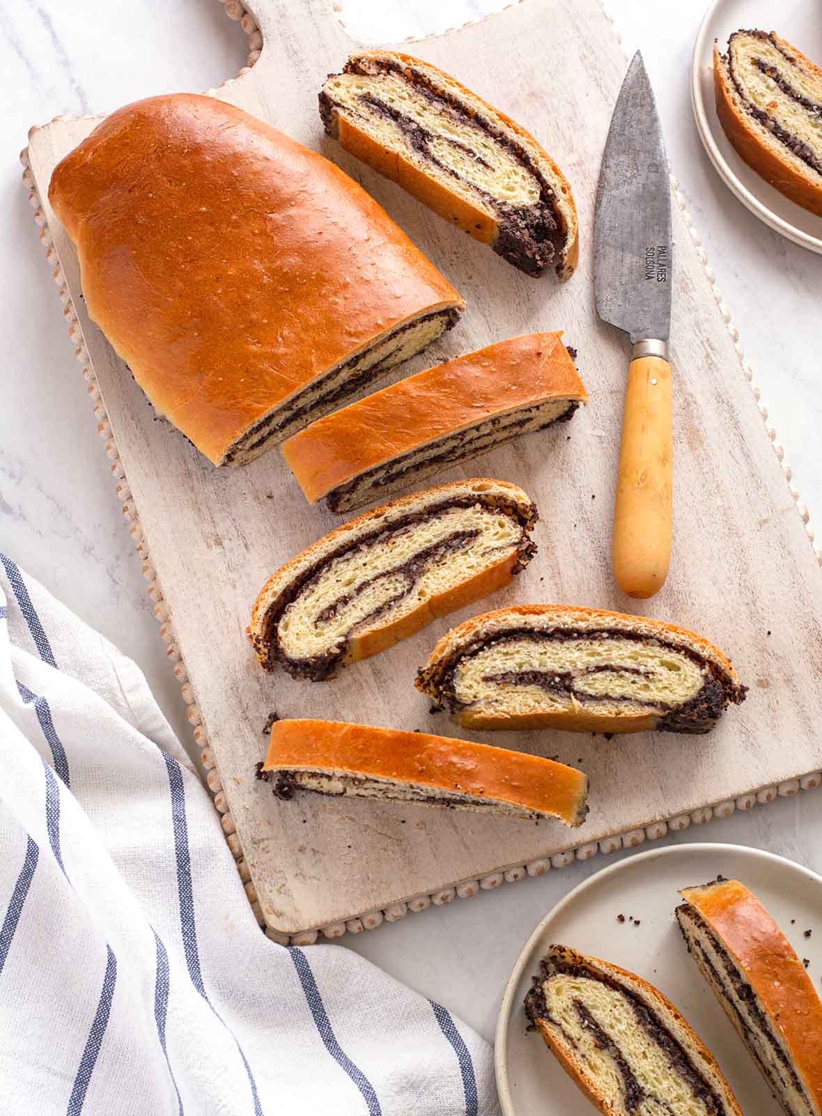 Нарізаний маковий рулет на дошці з ножем і скибками